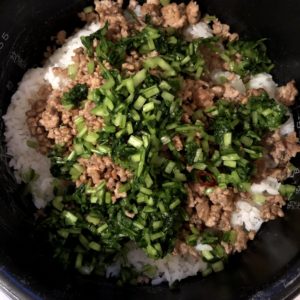 炊き上がったご飯に、壬生菜の漬物とそぼろを入れて混ぜ合わせます。